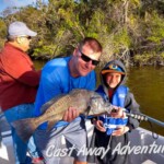 Saltwater fishing with family on a Cast Away Adventures guided tour in Cocoa Beach Florida, showcasing an excited young angler holding a sizable fish in a scenic river setting.