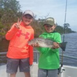Kids enjoying fishing adventure with a catch at Cast Away Adventures in Florida.