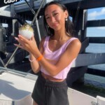 Woman holding a pufferfish on a boat during Cast Away Adventures, Florida, with clear blue skies, perfect for sea life exploration and adventure tourism.