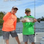Kids fishing adventure with catch on a boat at Cast Away Adventures, family-friendly outdoor activity, exploring nature, angling, and fishing in Florida's waterways.